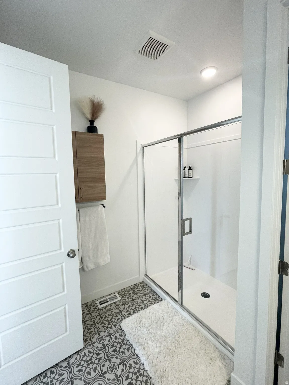 Full bath with a stall shower and baseboards