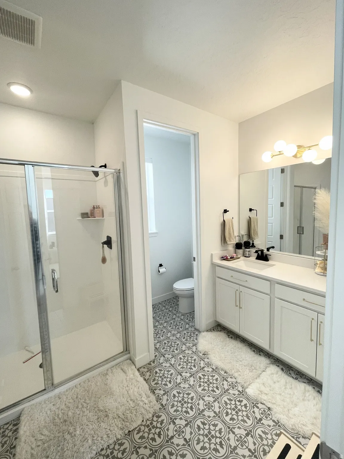 Bathroom featuring a shower stall and vanity