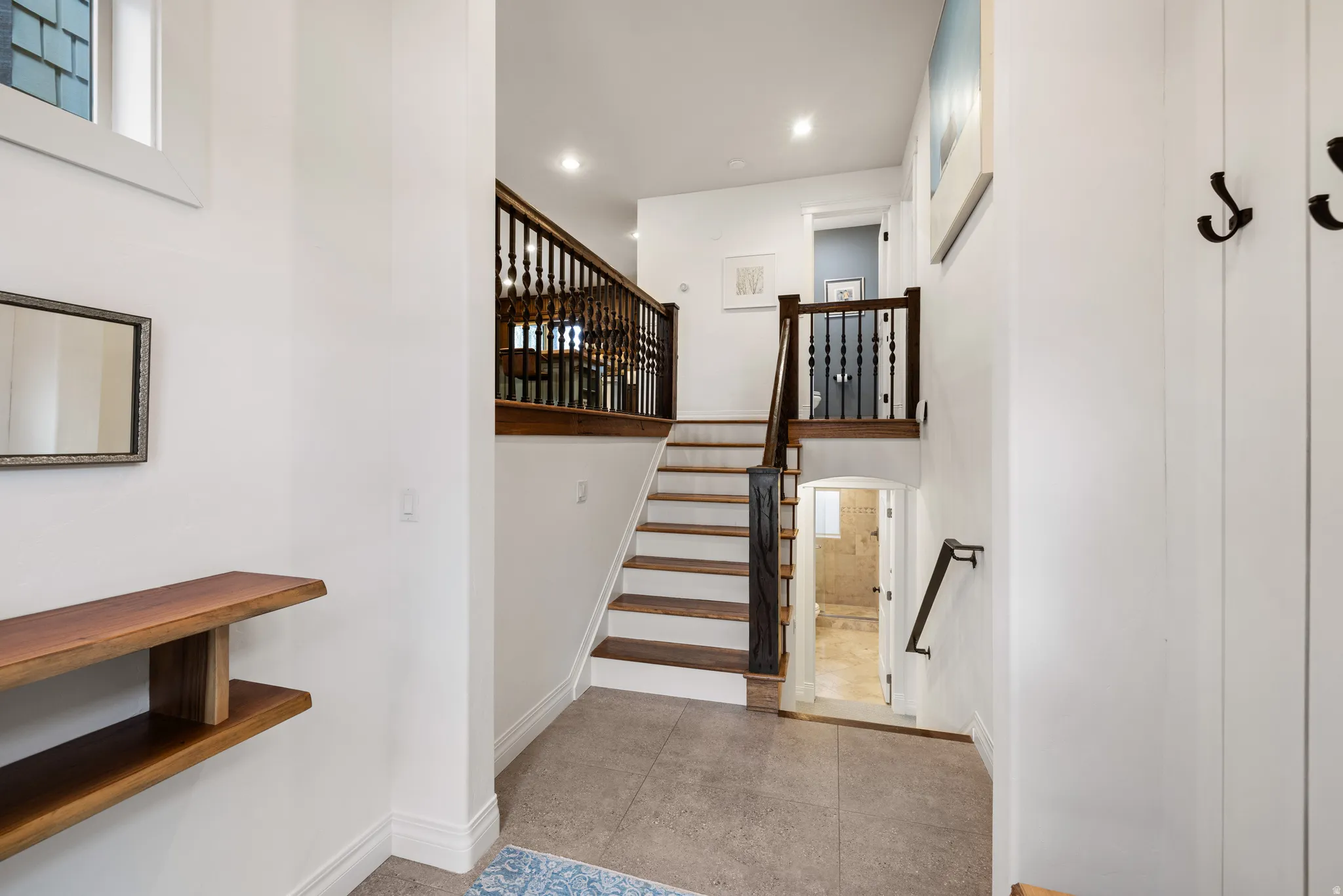 Stairway featuring tile patterned flooring, recessed lighting, and arched walkways