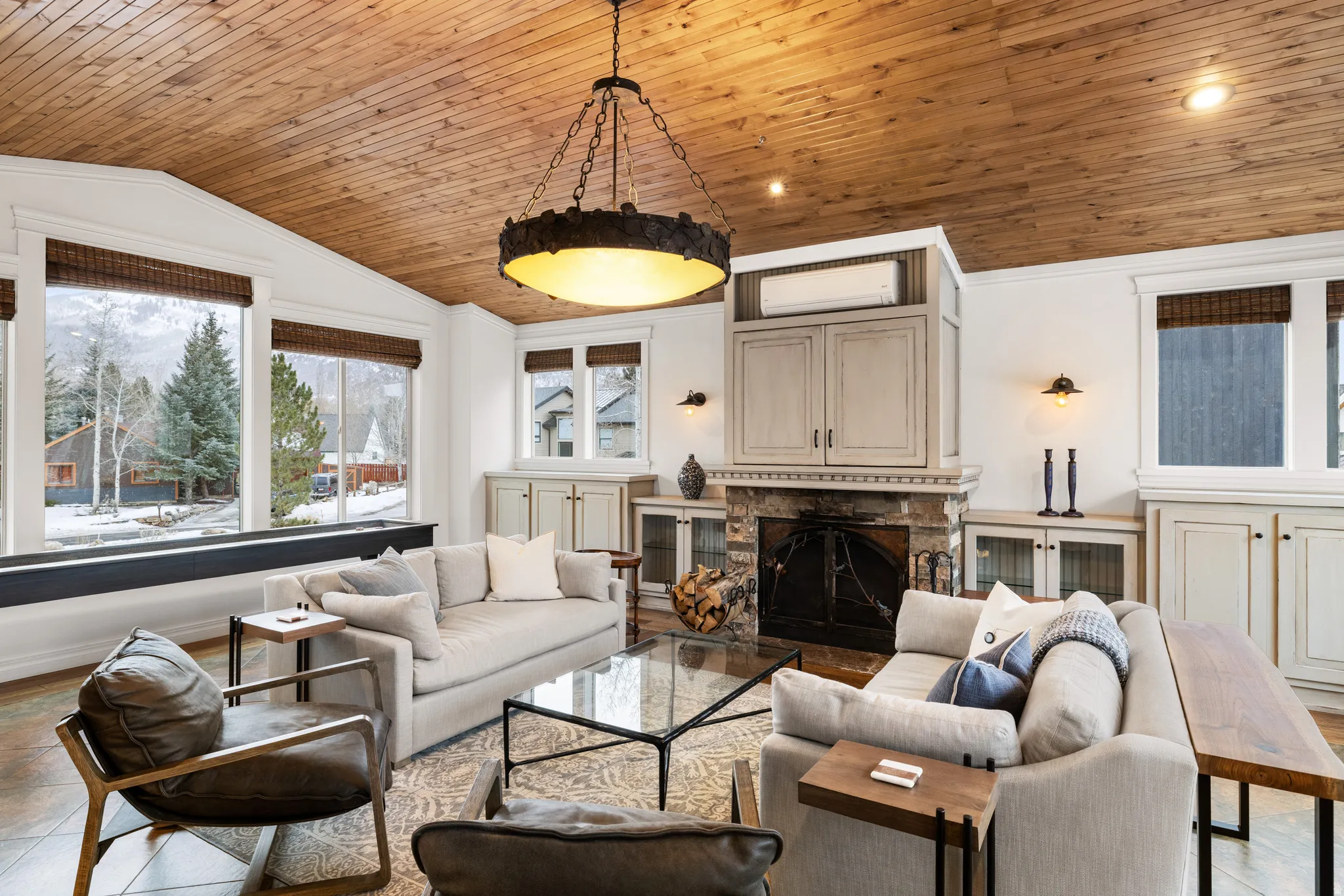 Living area featuring plenty of natural light, a stone fireplace, a vaulted wood ceiling, and recessed lighting
