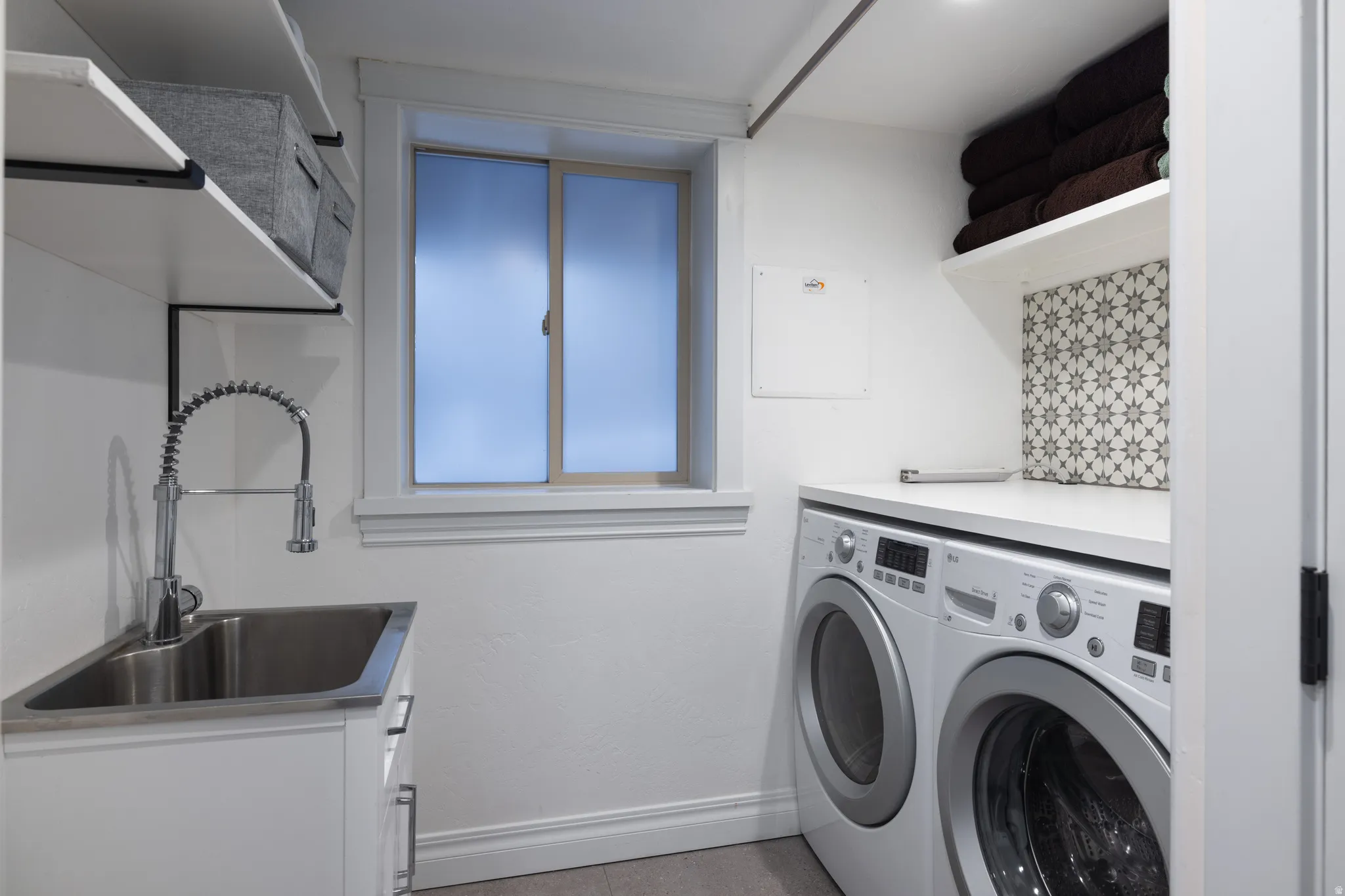 Laundry area with washer and dryer and baseboards
