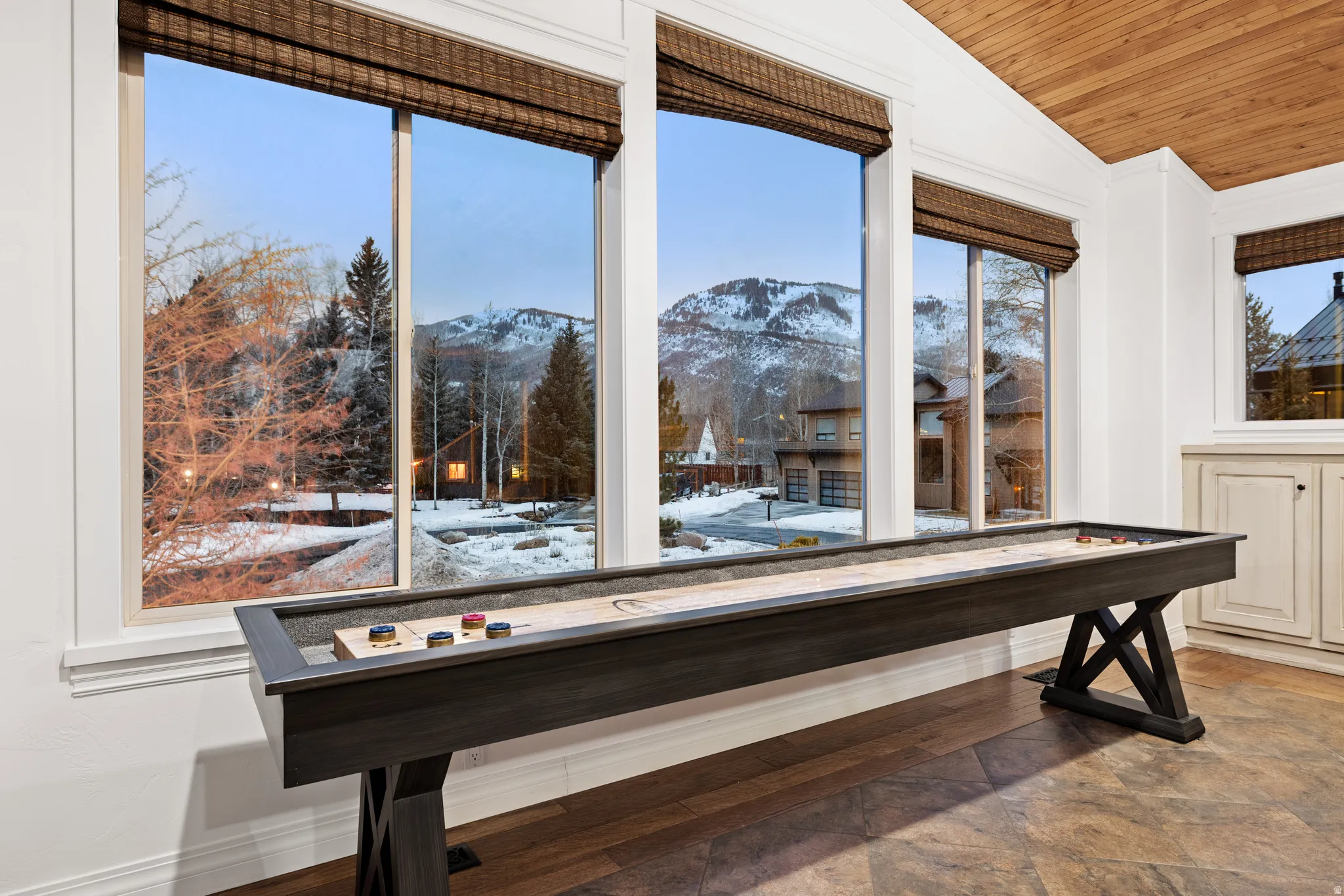 Recreation room featuring a mountain view, a vaulted wooden ceiling, and wood finished floors