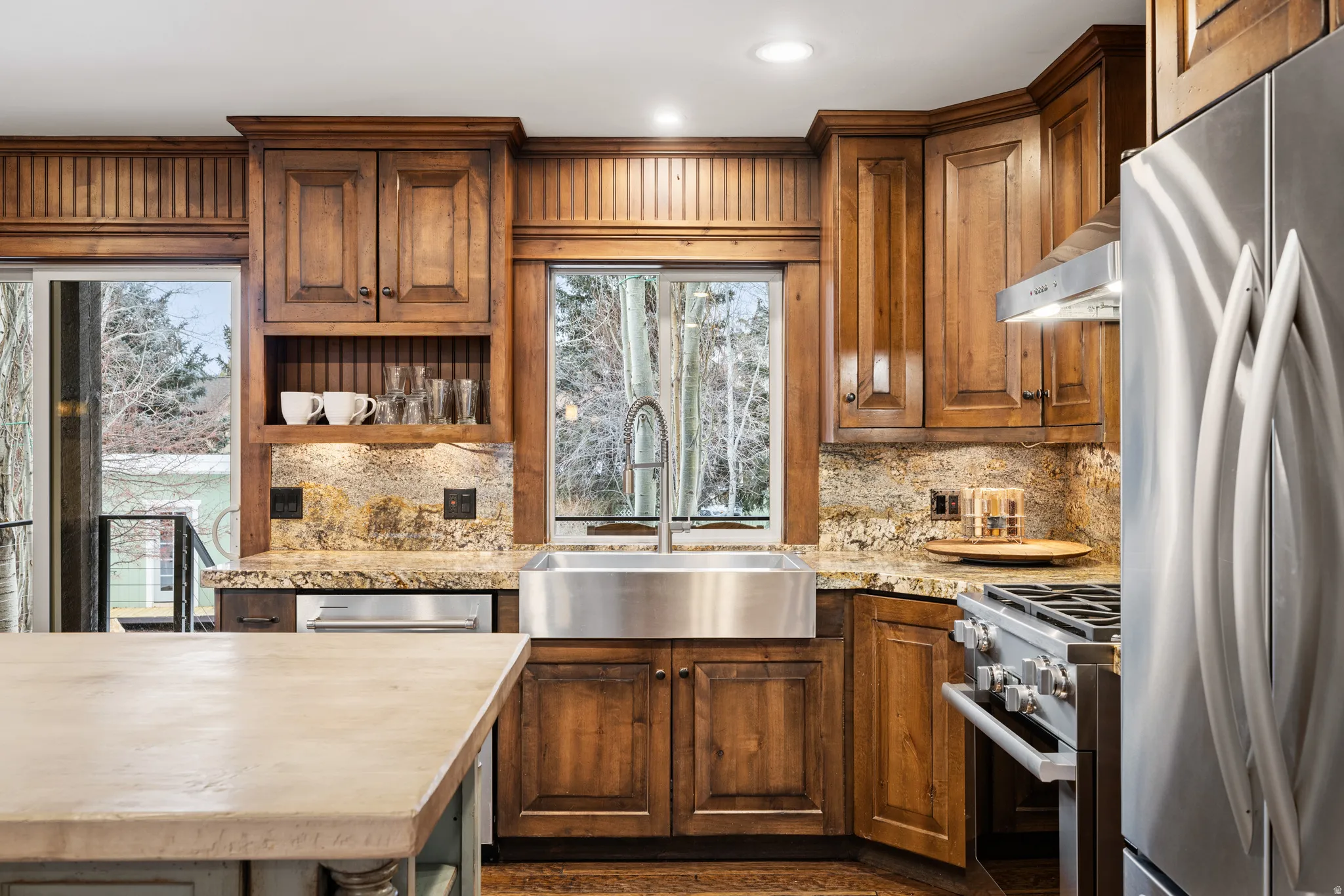 Kitchen featuring stainless steel appliances, open shelves, tasteful backsplash, wood finish cabinetry, and recessed lighting
