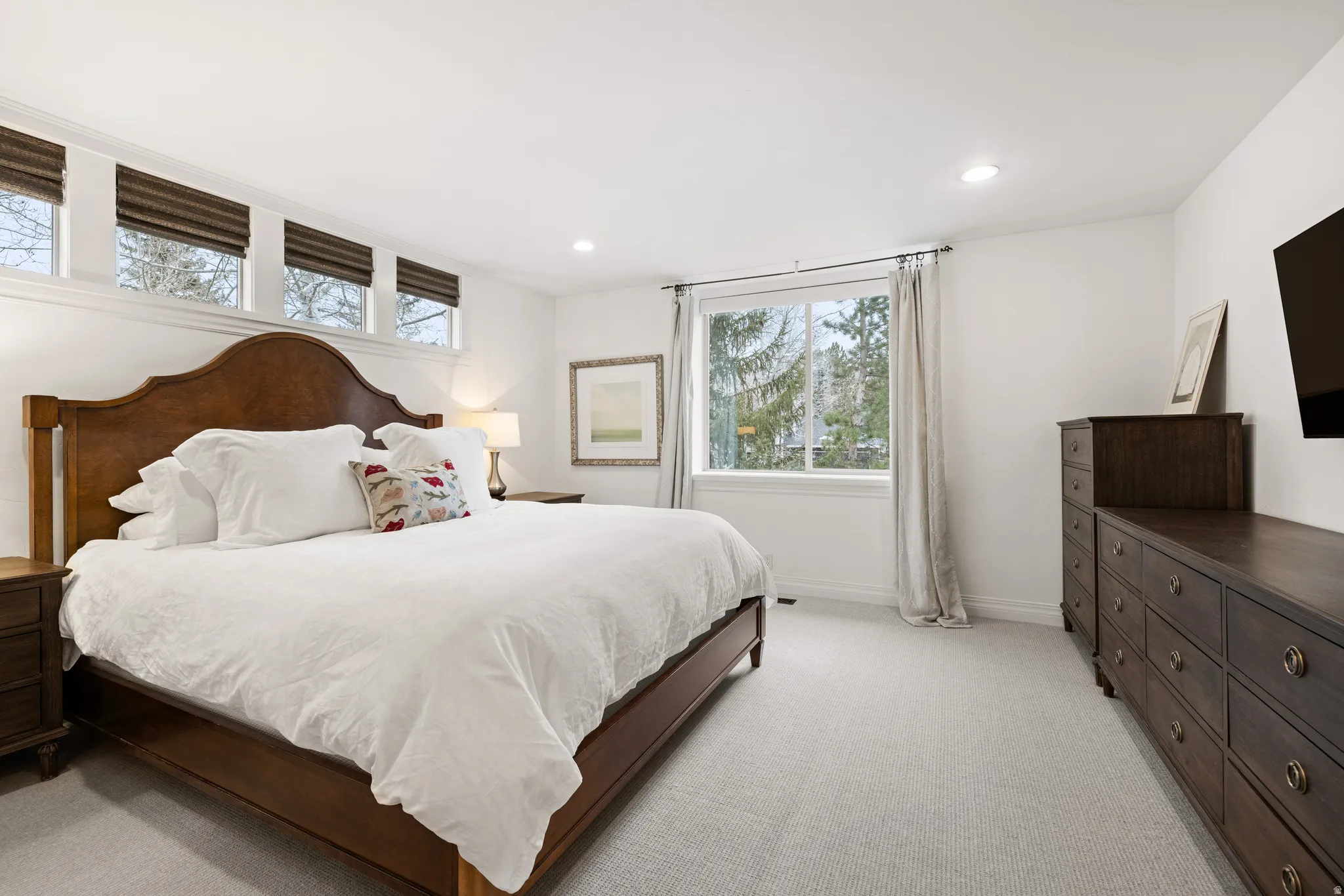 Bedroom with light colored carpet and recessed lighting