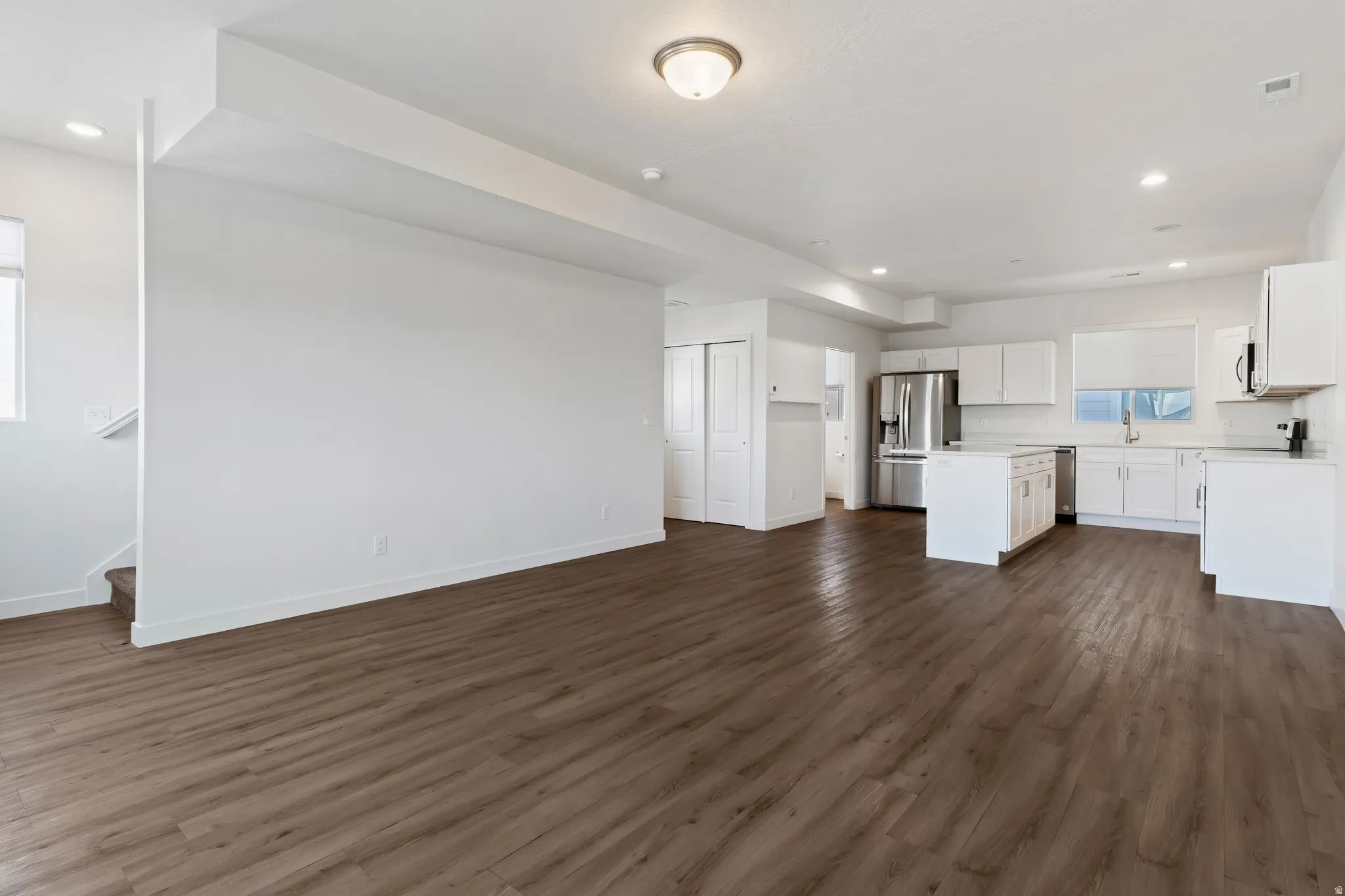 Unfurnished living room featuring recessed lighting and dark wood-type flooring