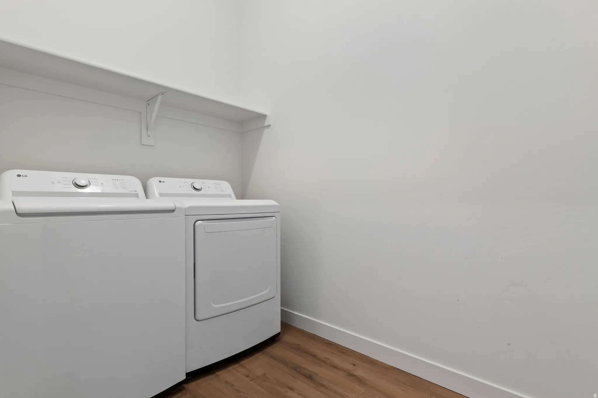Laundry area featuring washer and clothes dryer and dark wood-type flooring