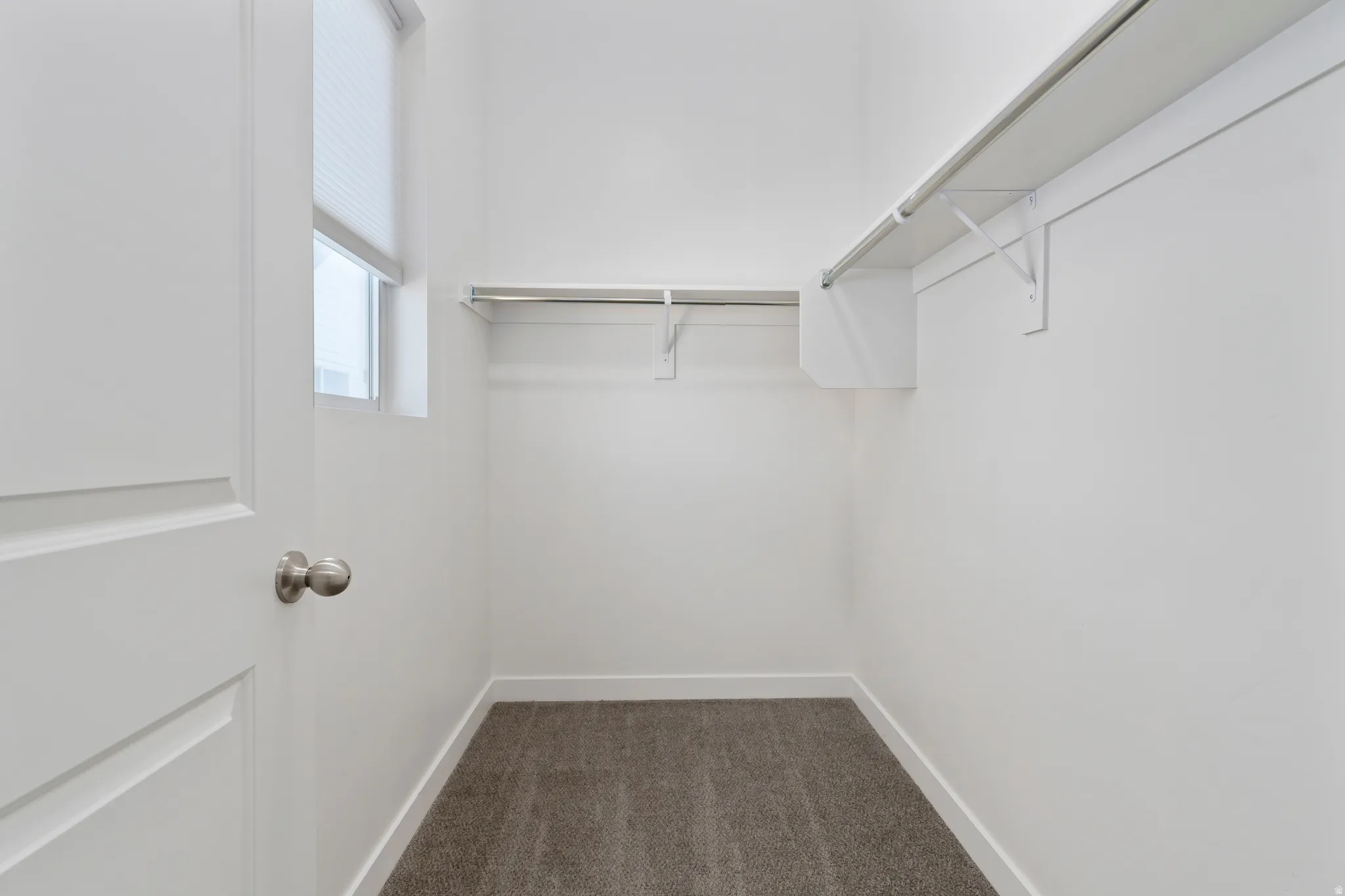 Walk in closet with dark carpet