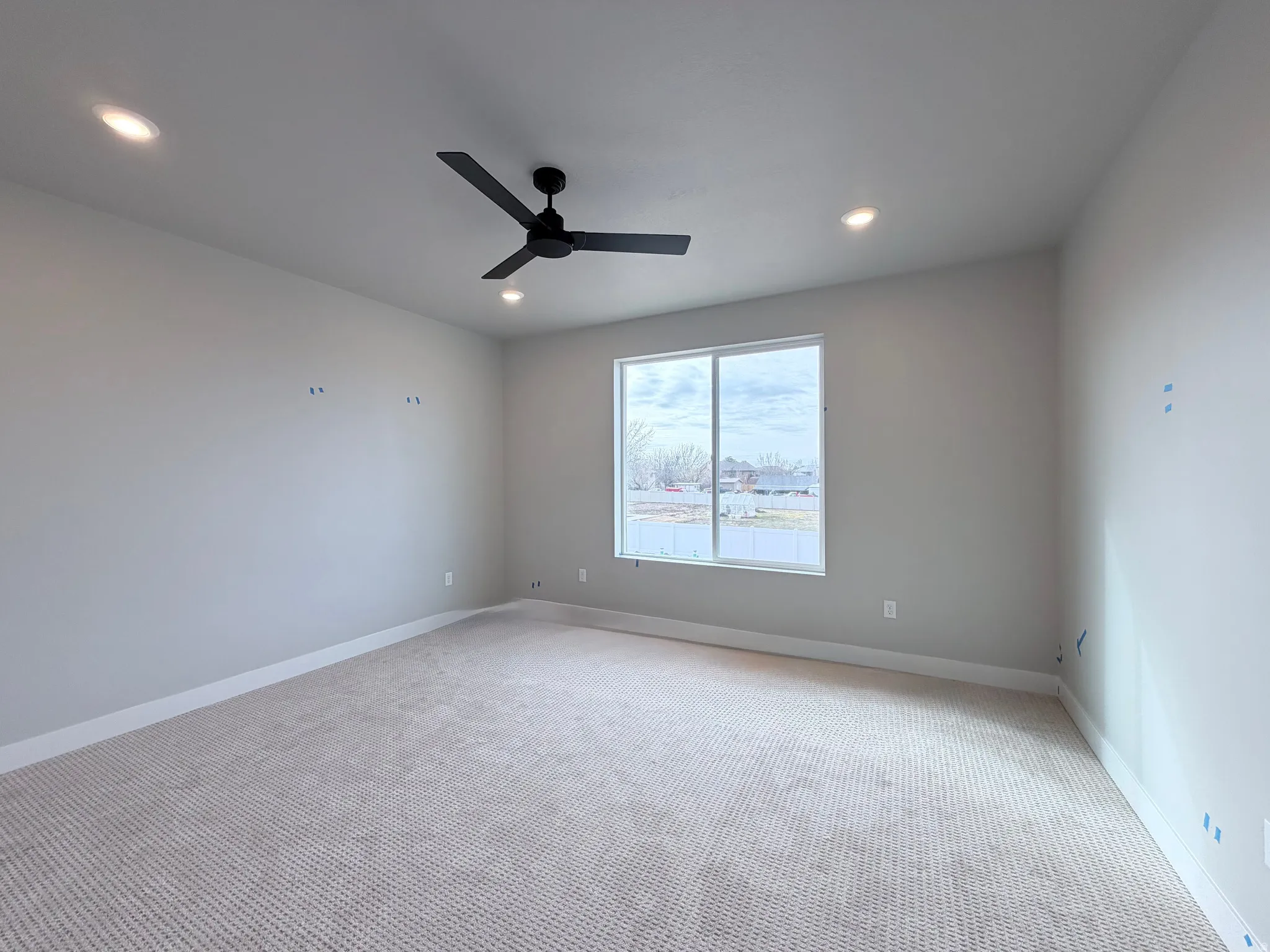 Carpeted empty room with ceiling fan and recessed lighting