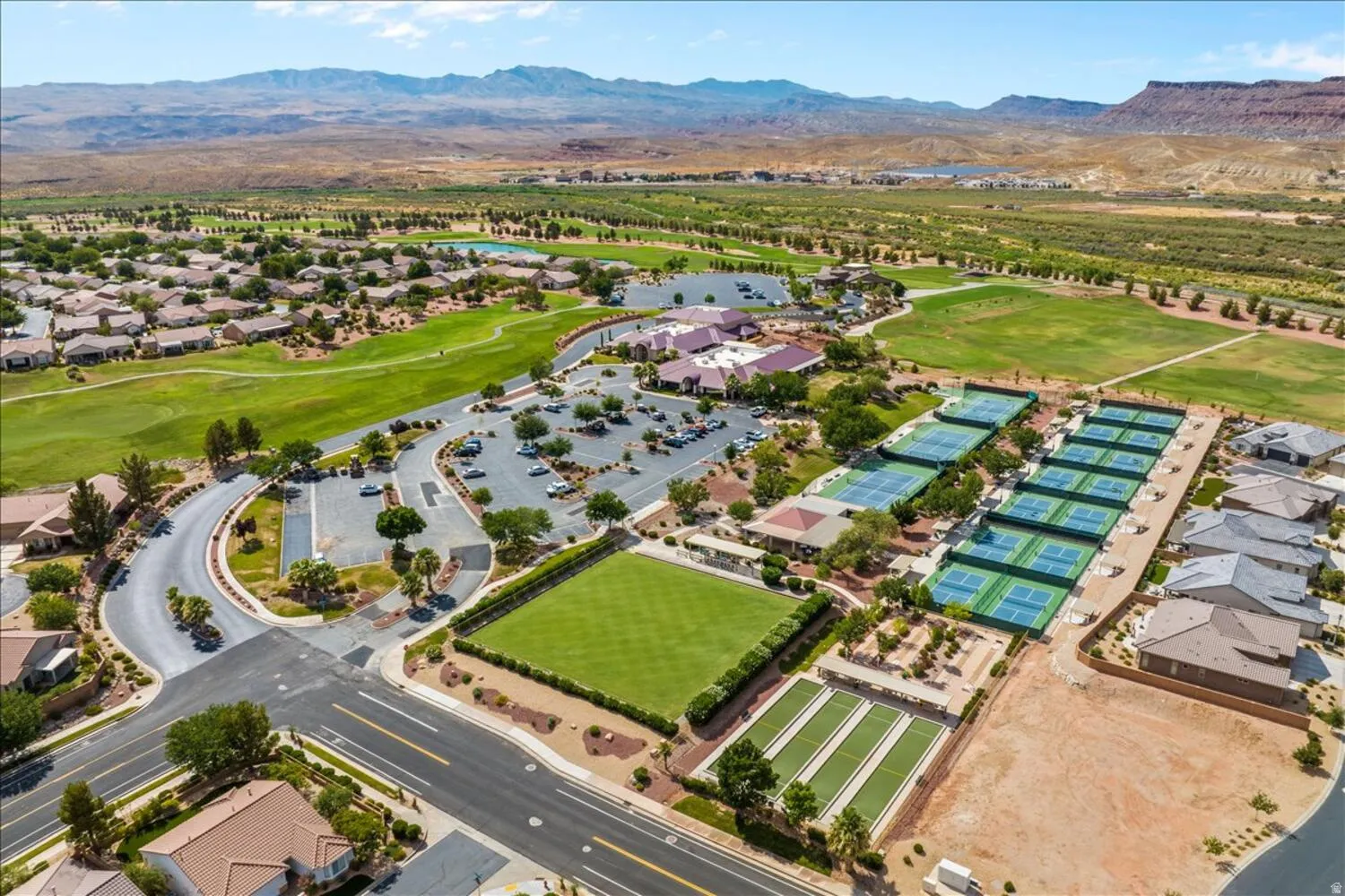 Aerial perspective of suburban area with a golf club and a water and mountain view