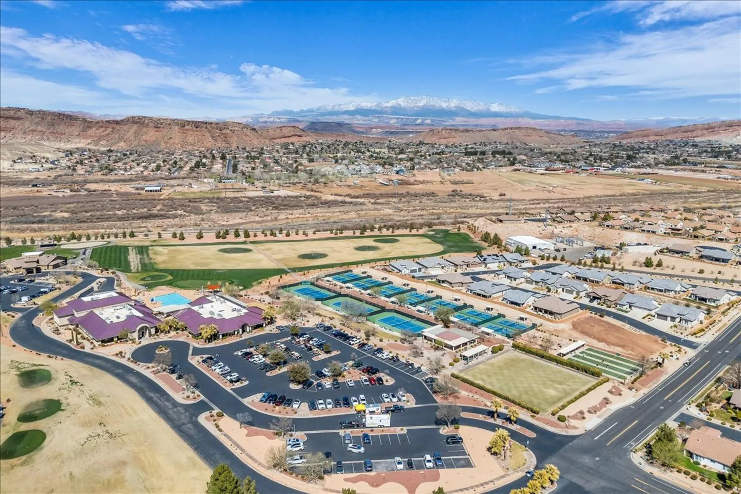 Drone / aerial view of a mountain backdrop and a golf club