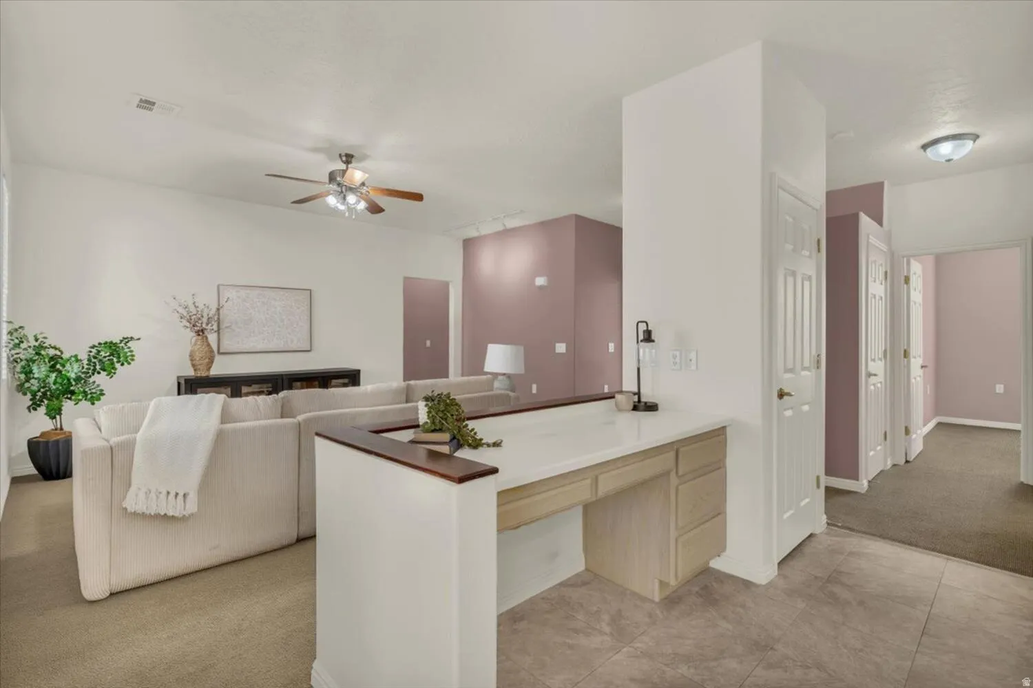 Kitchen with light wood finish cabinetry, ceiling fan, light carpet, a peninsula, and open floor plan