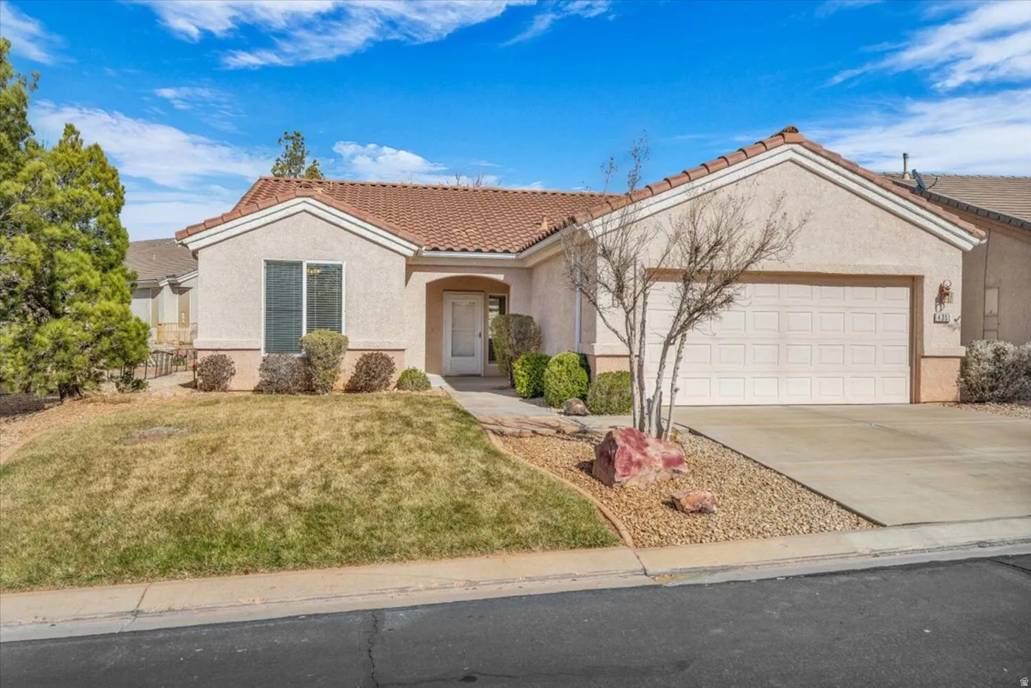 Mediterranean / spanish-style home with a front lawn, a tile roof, stucco siding, concrete driveway, and an attached garage