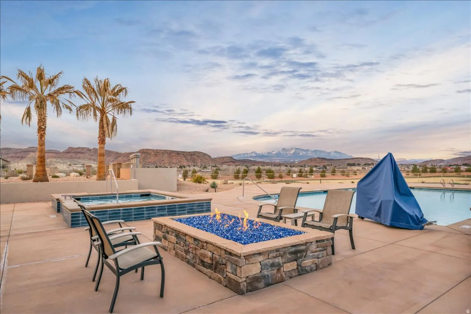 Community pool with a mountain view, an outdoor fire pit, a hot tub, and a patio