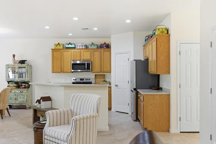 Kitchen with light countertops, stainless steel appliances, wood finish cabinetry, recessed lighting, and light tile patterned floors