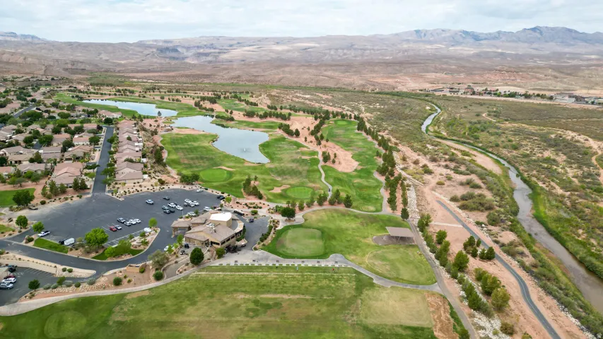 Aerial overview of property's location featuring a golf club, a water and mountain view, and nearby suburban area