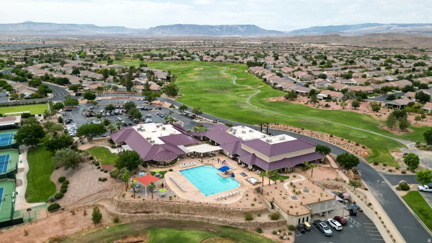 Aerial overview of property's location featuring a golf course and nearby suburban area