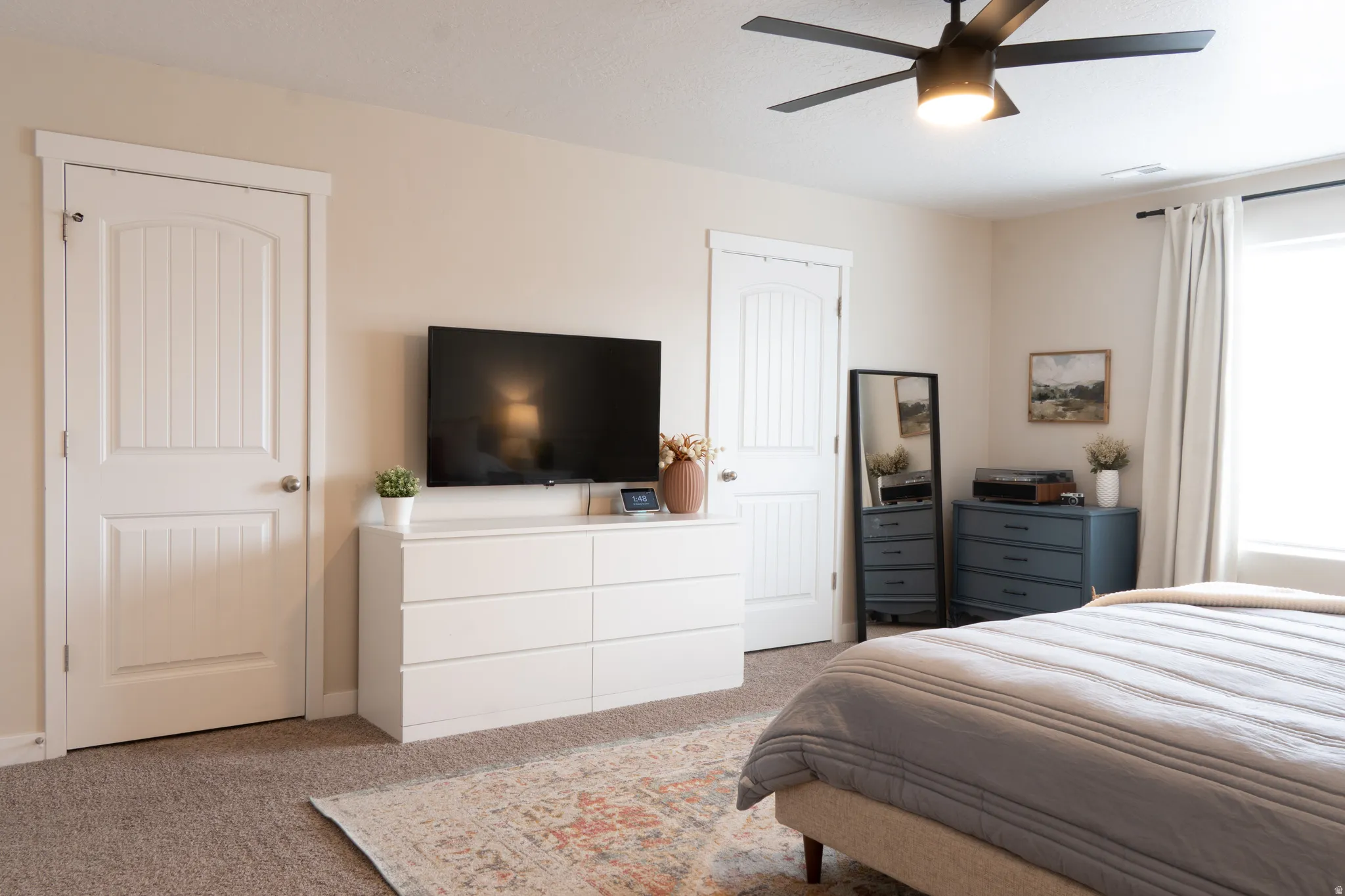 Bedroom with light colored carpet and ceiling fan