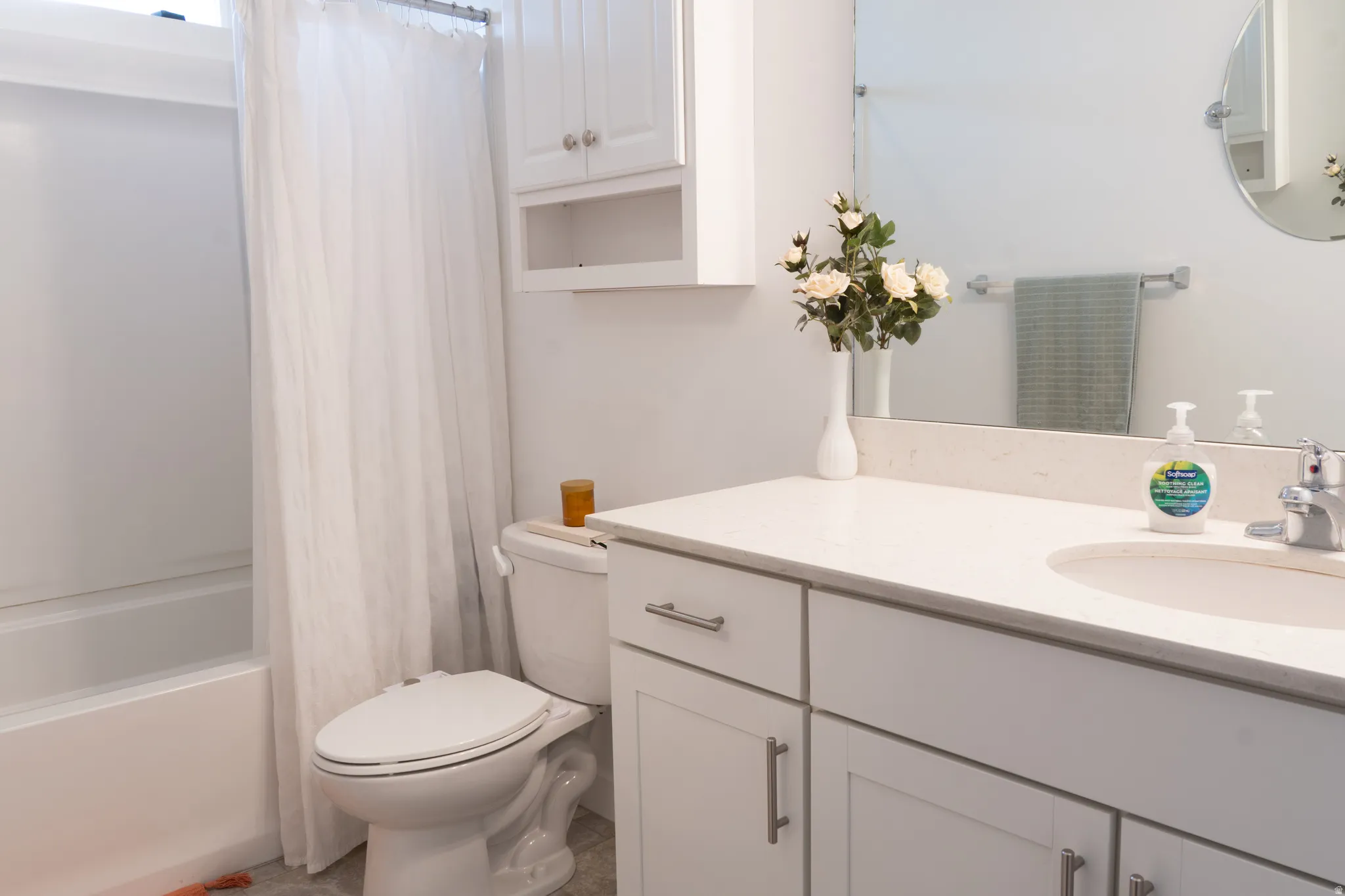 Bathroom featuring vanity and shower / bath combination with curtain