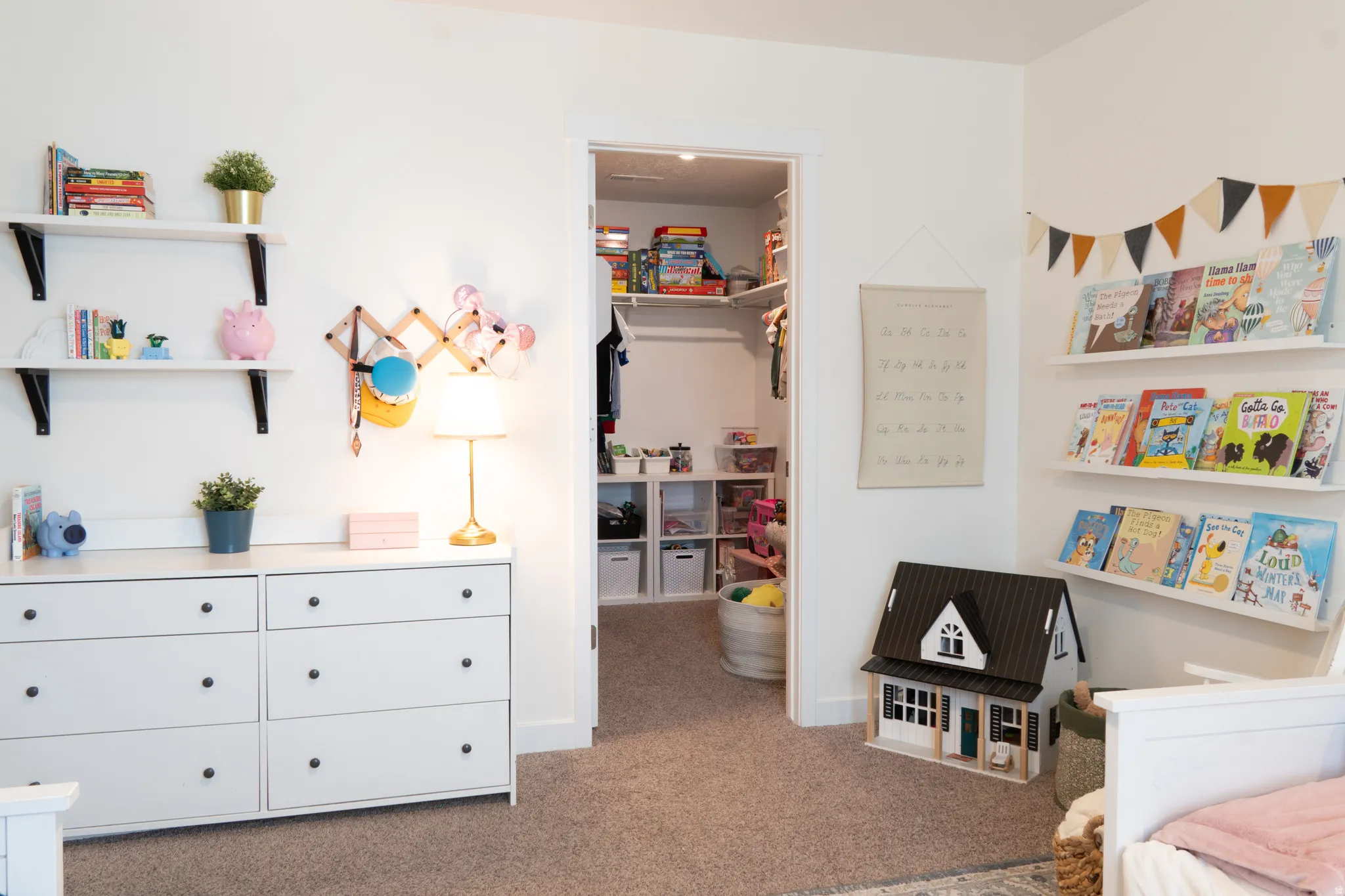 Bedroom with light carpet and a walk in closet