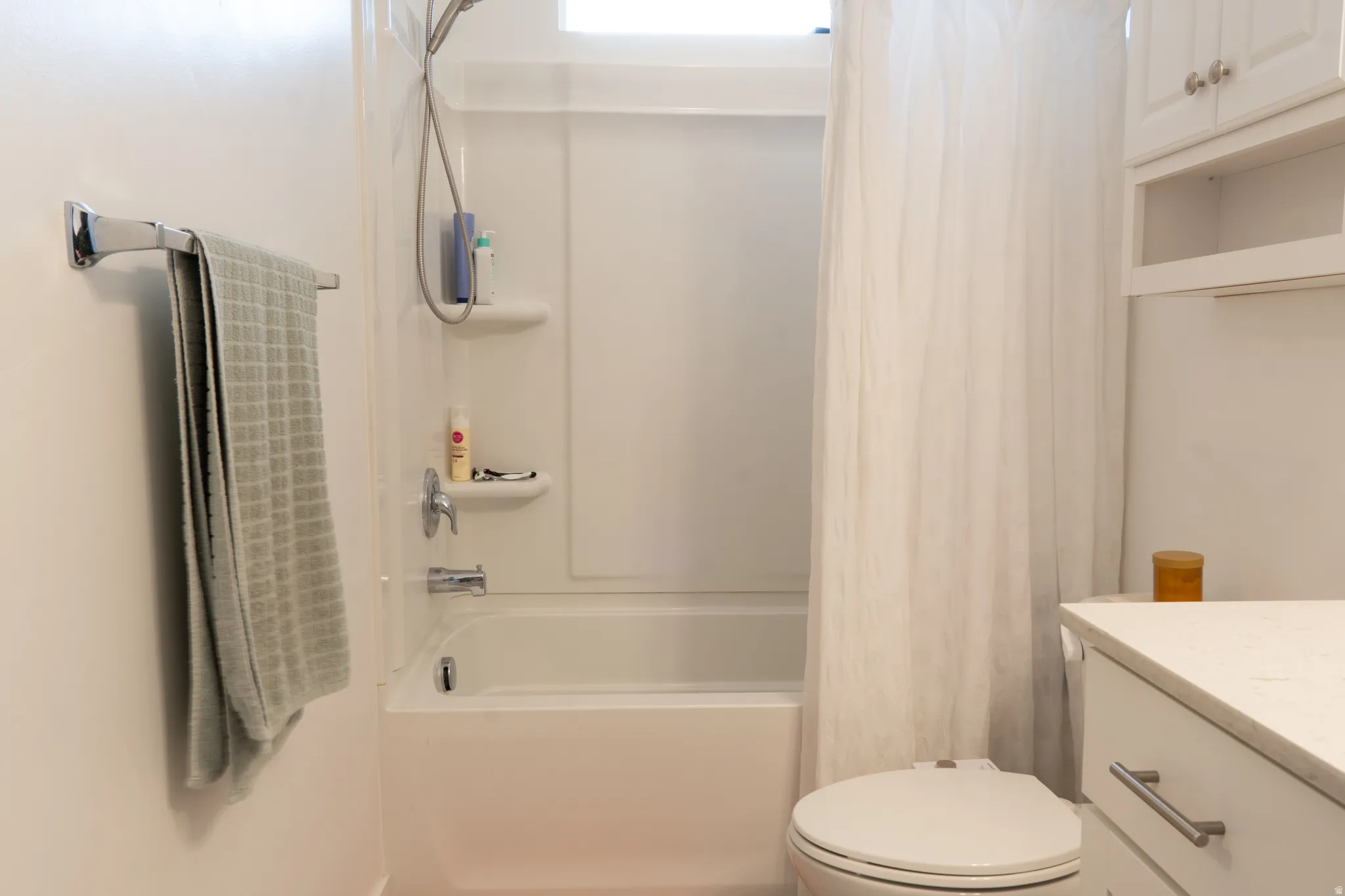 Bathroom featuring vanity and shower / tub combo with curtain