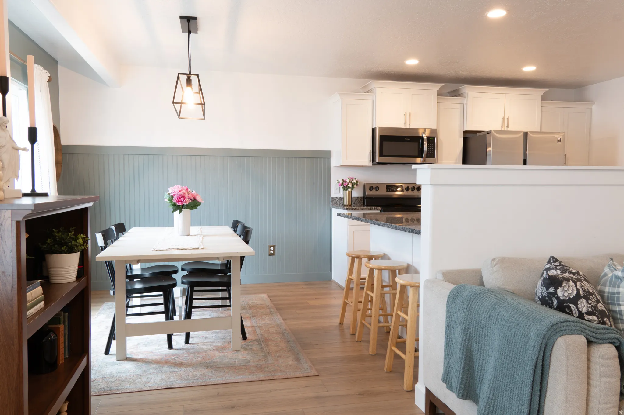 Dining room featuring wainscoting, light wood finished floors, and recessed lighting