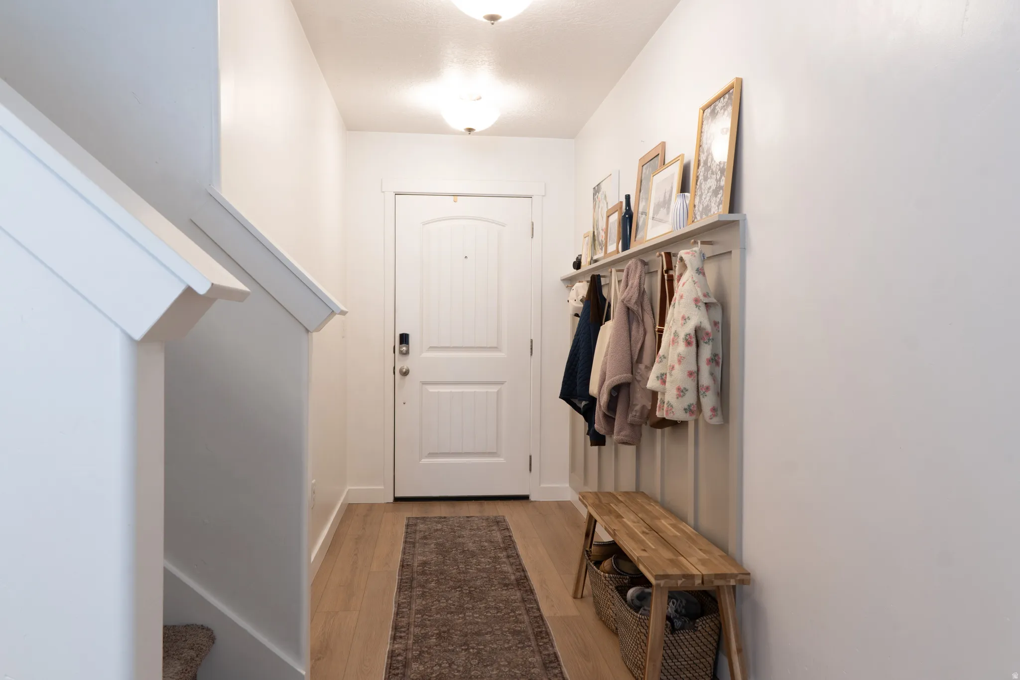 Mudroom with light wood-style floors and baseboards