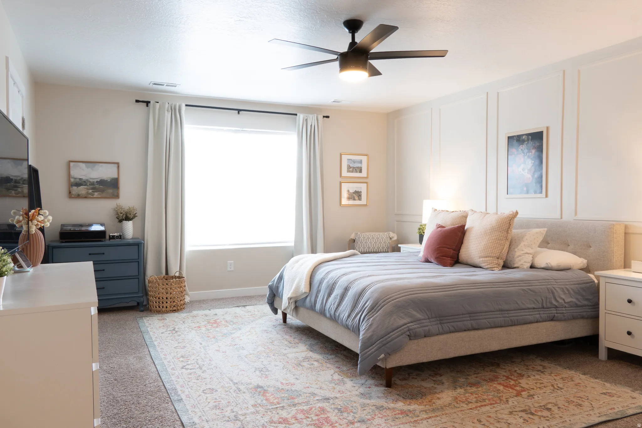 Carpeted bedroom with a decorative wall and a ceiling fan