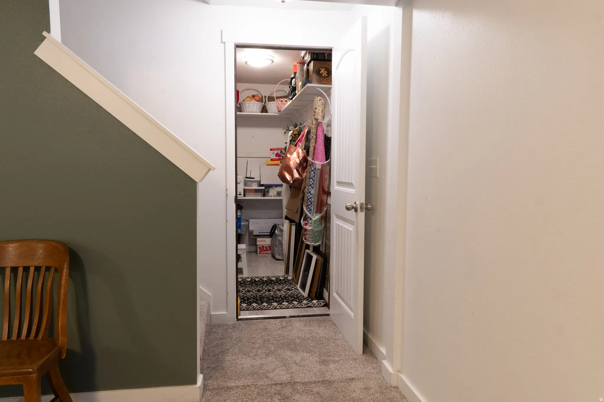 Hall with light colored carpet and baseboards