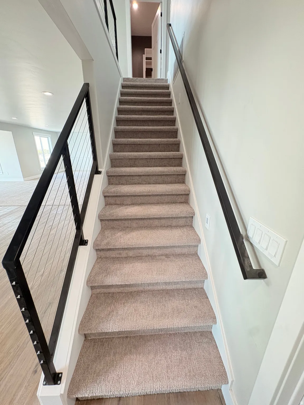 Stairway with wood finished floors and recessed lighting