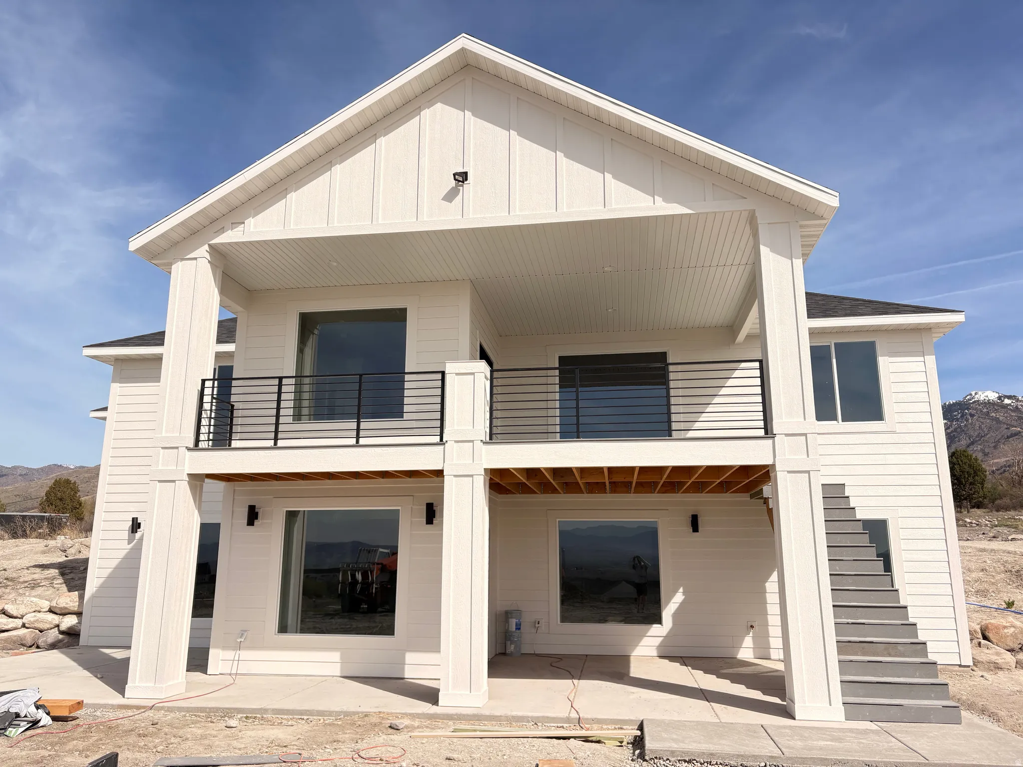 Rear view of house featuring a mountain view, a patio area, a balcony, and board and batten siding
