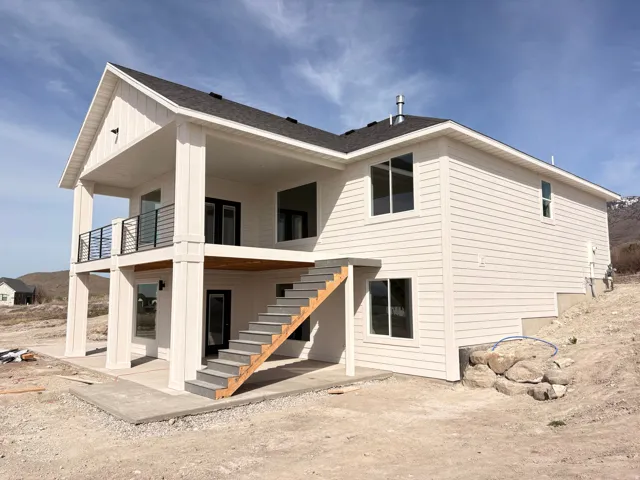 Rear view of property with a patio area and roof with shingles