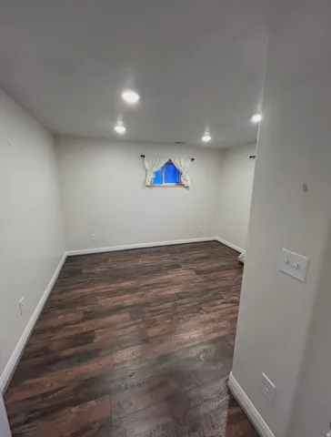 Basement featuring dark wood-type flooring and recessed lighting