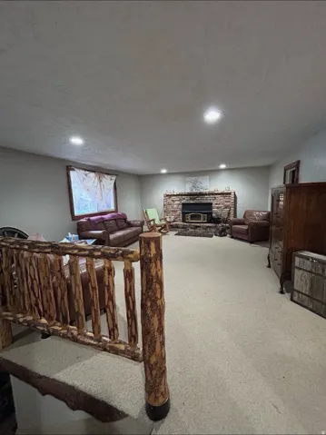 Living room featuring a glass covered fireplace, carpet floors, a textured ceiling, and recessed lighting