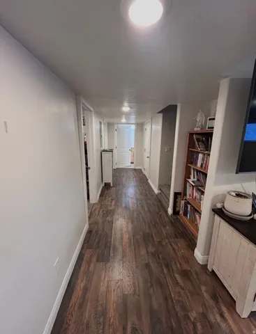 Hall with dark wood finished floors and baseboards