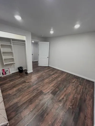 Unfurnished bedroom with dark wood-type flooring and a closet
