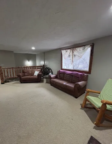 Living area featuring carpet floors and a textured ceiling