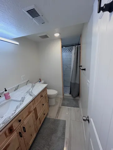 Bathroom featuring a shower stall, vanity, and a textured ceiling