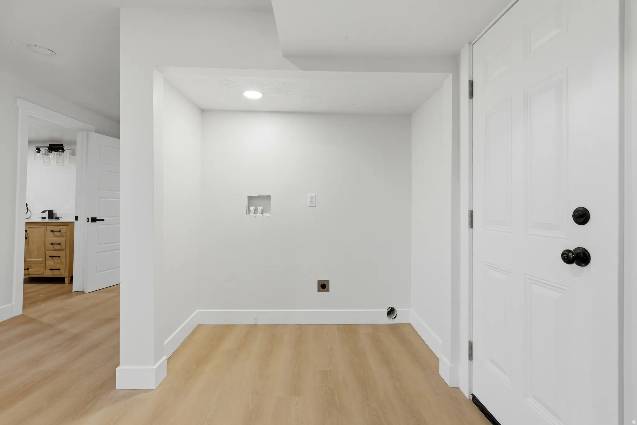 Laundry area featuring hookup for a washing machine, light wood finished floors, recessed lighting, and electric dryer hookup