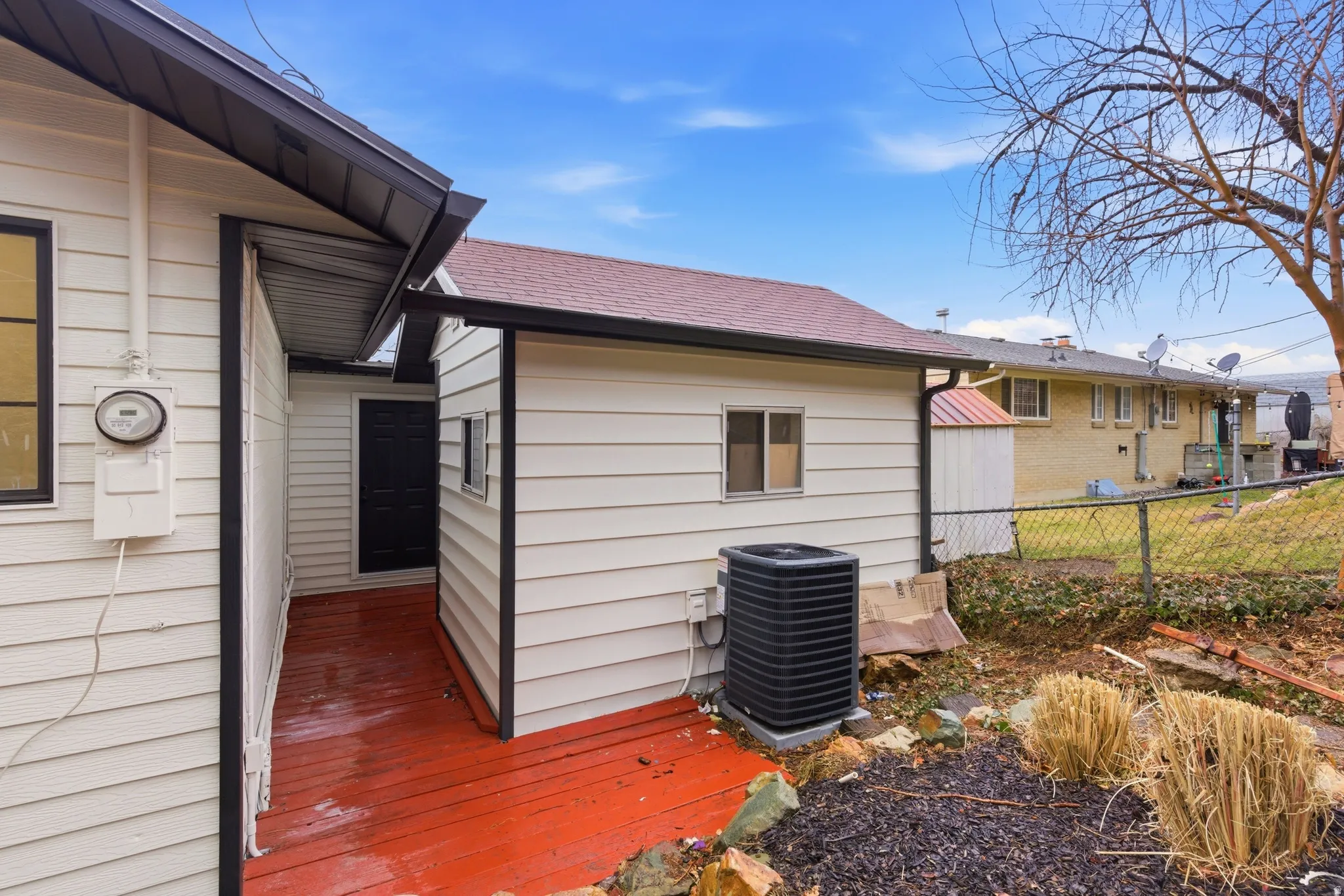 View of side of property with roof with shingles and a wooden deck