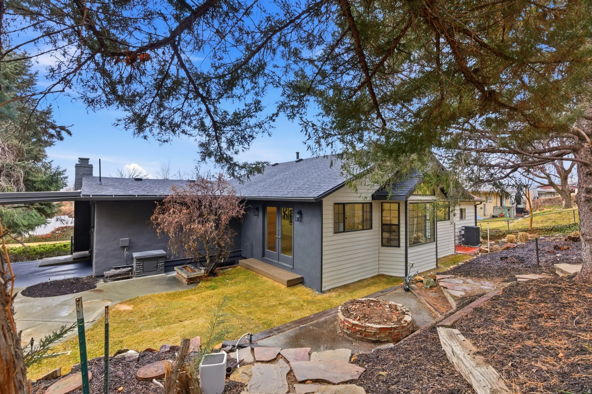 View of front of house featuring a shingled roof, french doors, a patio, and a chimney