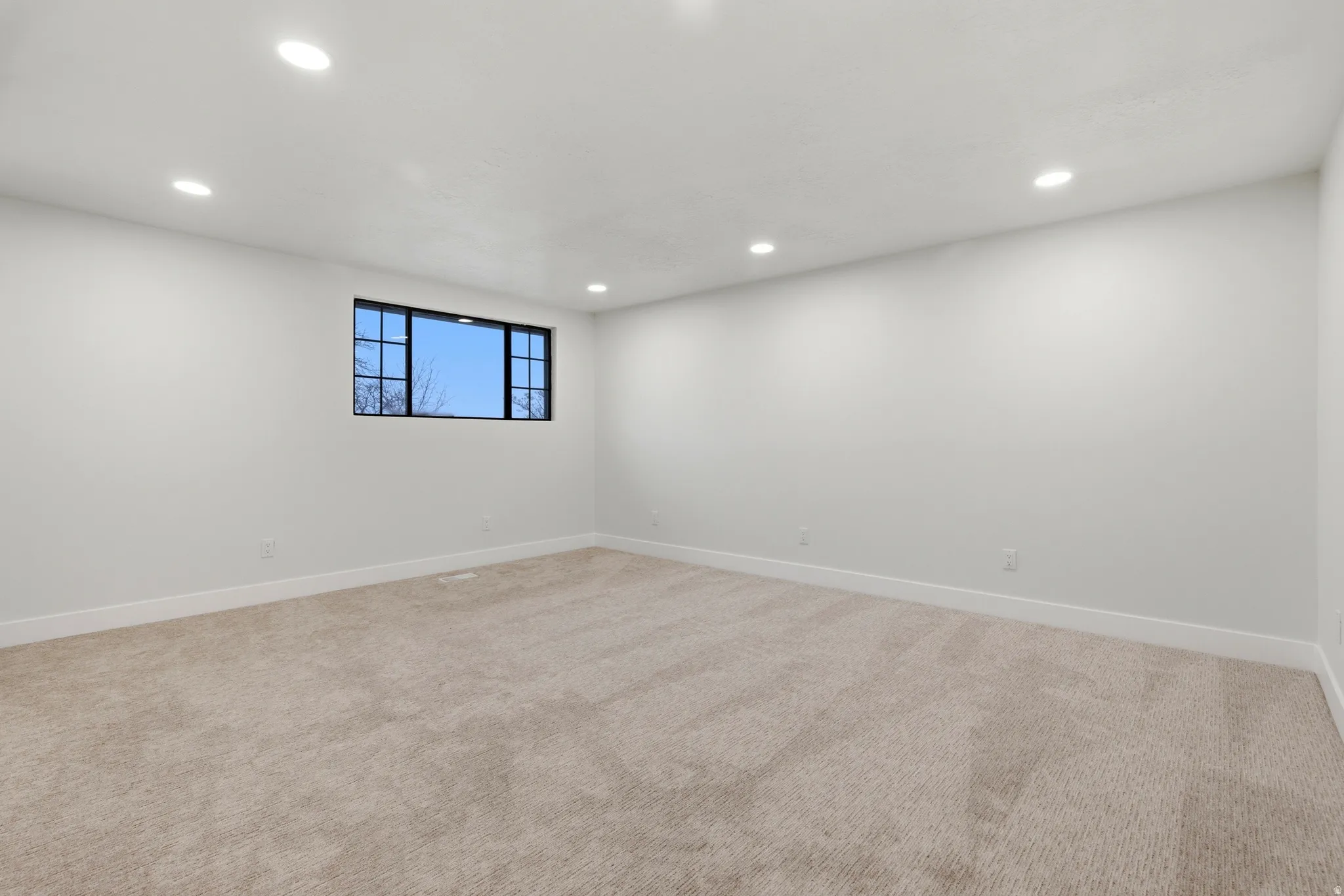 Spare room featuring light carpet and recessed lighting