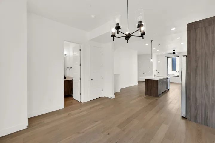 Unfurnished dining area featuring light wood-type flooring and suspended lighting