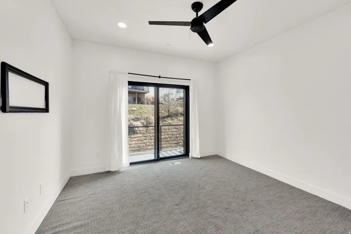 Carpeted empty room featuring ceiling fan and recessed lighting