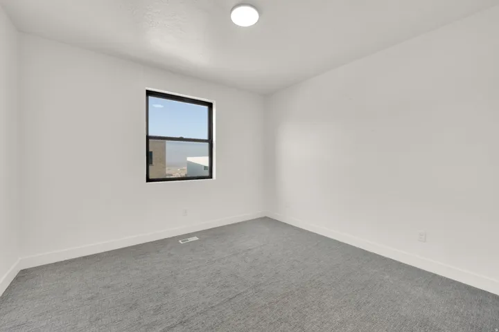 Unfurnished room with carpet and baseboards