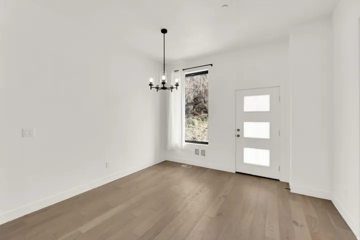 Foyer featuring suspended lighting and light wood-style flooring