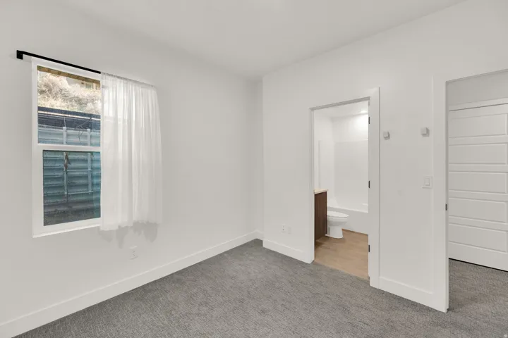 Unfurnished bedroom with carpet and ensuite bathroom