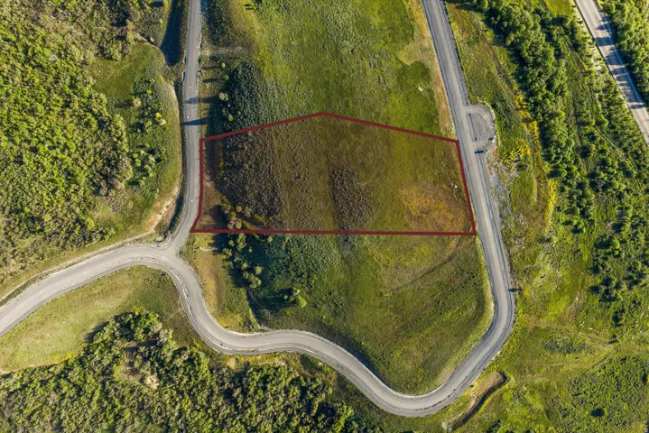 Expansive land parcel featuring natural topography, established road frontage, and surrounding green spaces