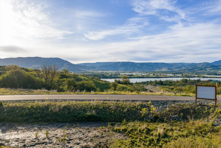 Expansive land parcel featuring distant mountain ranges and multiple bodies of water