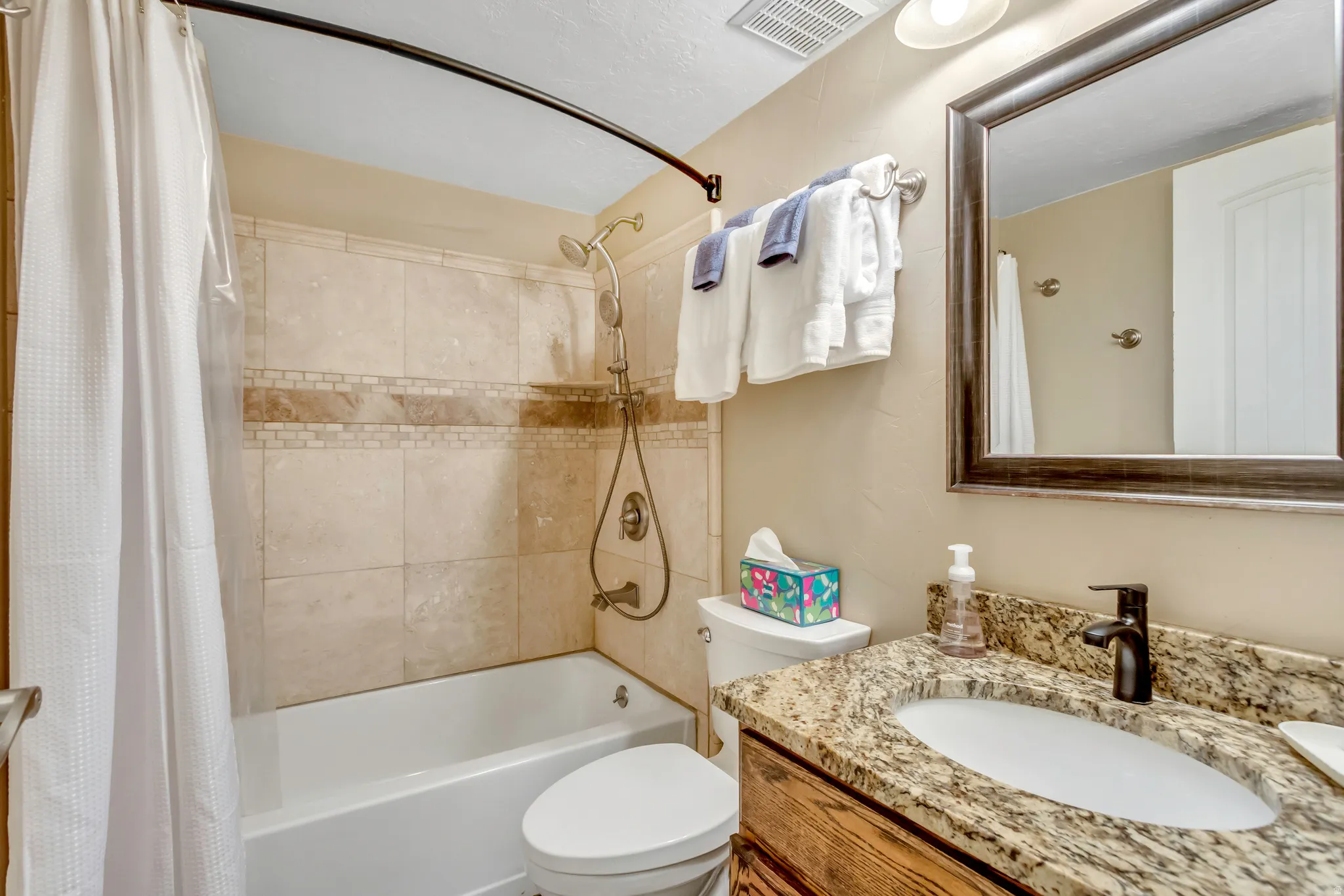 Bathroom featuring shower / bath combo with shower curtain and vanity
