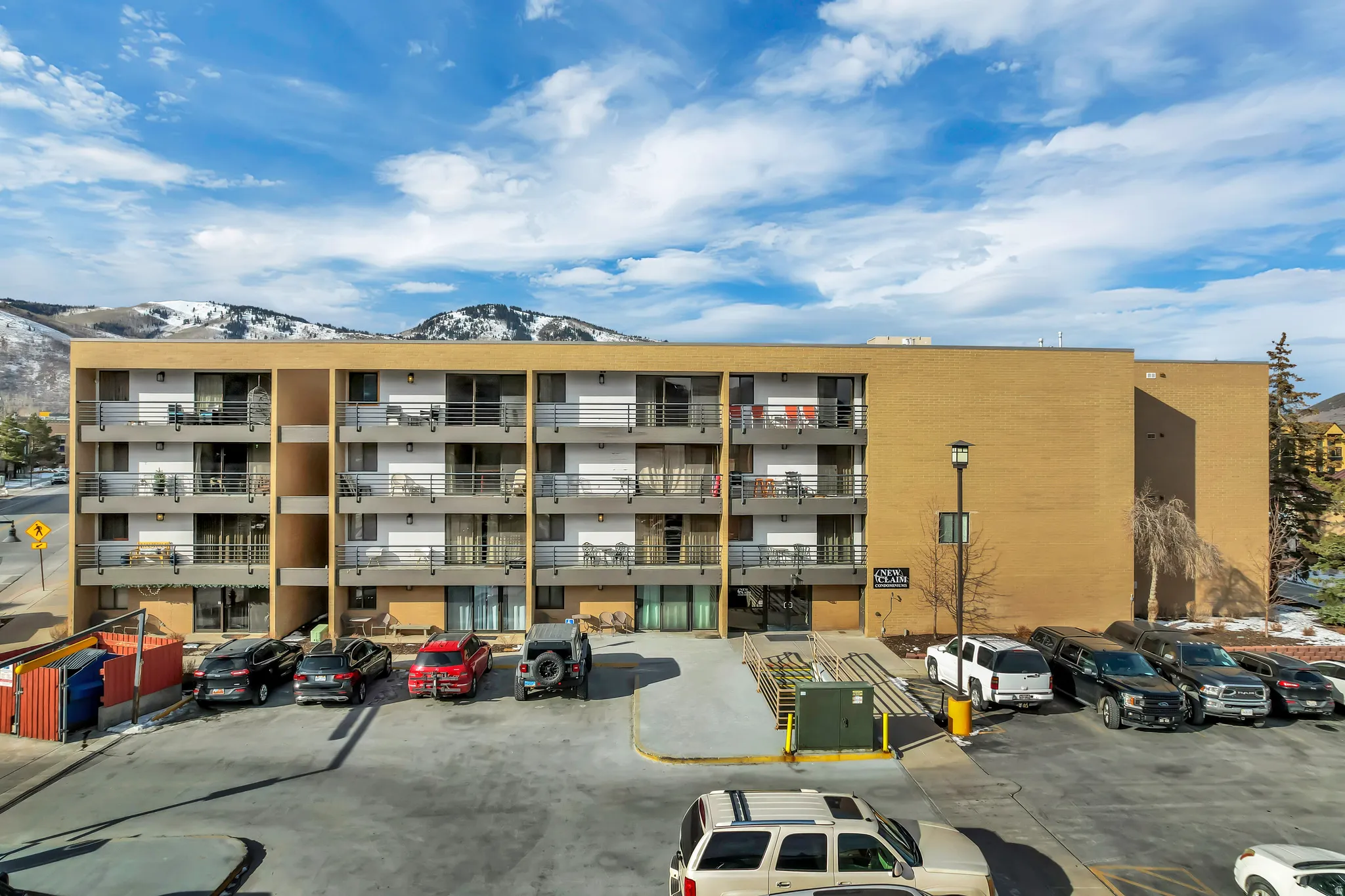 View of apartment building / complex with a mountain view and uncovered parking